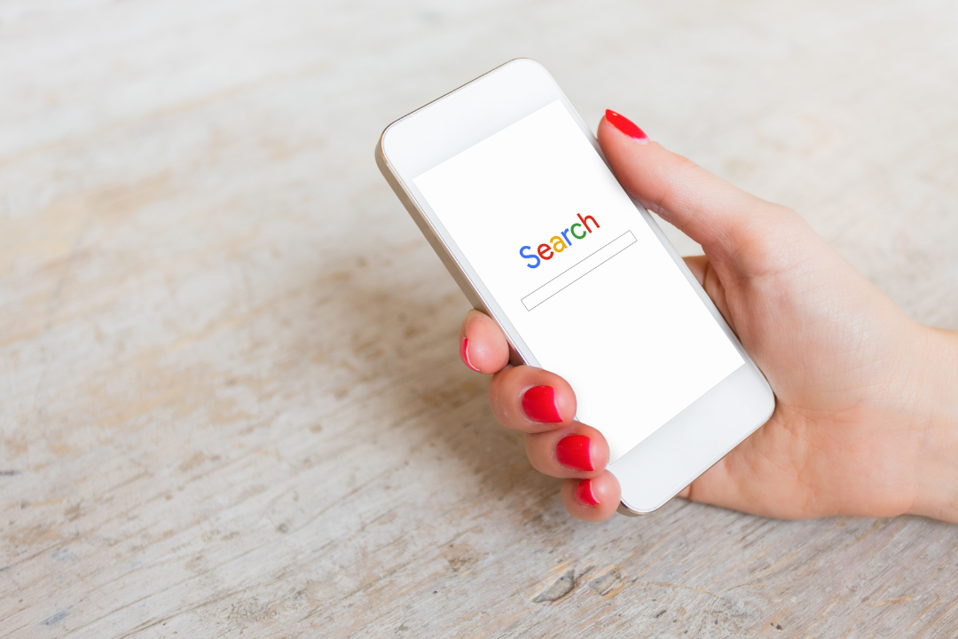 A smartphone displaying a website with Google search rankings and SEO analytics